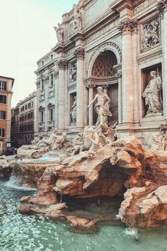 a fountain with statues on it in front of a building