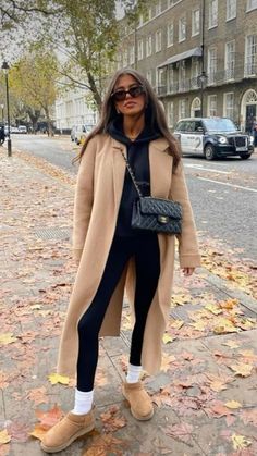 a woman is standing on the sidewalk with her hand in her pocket