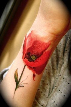 a woman's arm with a red flower on it