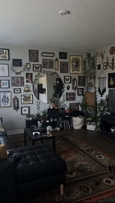 a living room filled with furniture and lots of framed pictures on the wall above it