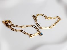 two gold chain bracelets with blue stones on them