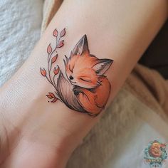 a small fox tattoo on the wrist