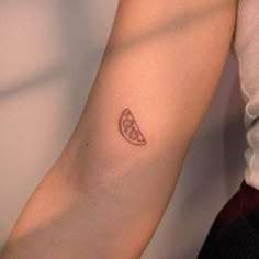 a small slice of fruit tattoo on the arm