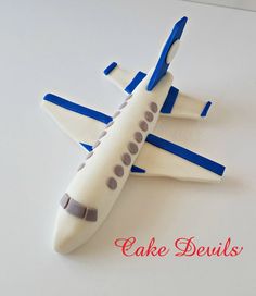 a cake shaped like an airplane on top of a white table with blue trimmings