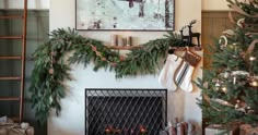 a decorated christmas tree in front of a fireplace