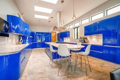 a large kitchen with blue cabinets and white counter tops is pictured in this image from the inside