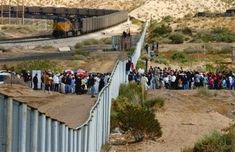 a group of people standing on the side of a train track