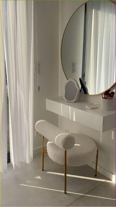 there is a white bench and mirror in the room