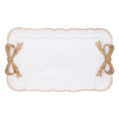 a white and gold serving tray with bows on the handles, decorated with roped ends