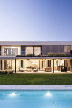 a house with a pool in front of it and grass on the lawn next to it