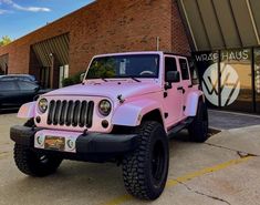 a pink jeep parked in front of a building