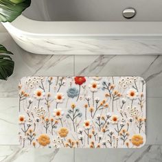 a bath mat with flowers on it next to a sink