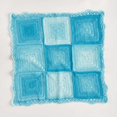 a blue crocheted square with squares on it, in the shape of squares