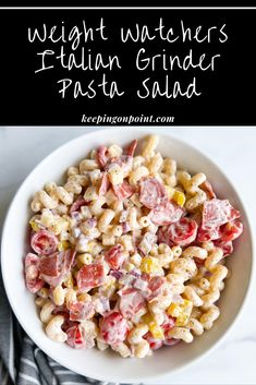 a white bowl filled with pasta salad on top of a table