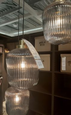 three glass lamps hanging from the ceiling in a store