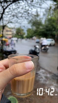 a person holding up a glass with liquid in it