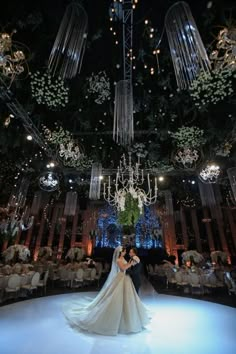 the bride and groom are standing in front of chandeliers at their wedding reception