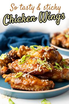 chicken wings with sesame seeds and green onions on a blue plate in front of the words so tasty & sticky chicken wings