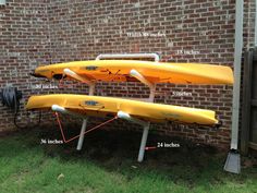 three yellow kayaks sitting on top of each other in front of a brick building