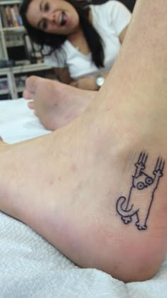 a person with a small tattoo on their foot that has an image of a cat