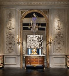 an ornate room with chandelier and paintings on the walls