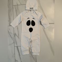 a baby's white onesuit with black eyes and nose