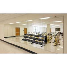 an empty gym room with mirrors reflecting the equipment on the wall and in the floor