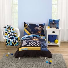 a bedroom with blue walls and batman bedding