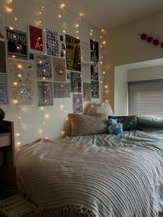 a bedroom with lights strung from the ceiling and pictures on the wall above the bed