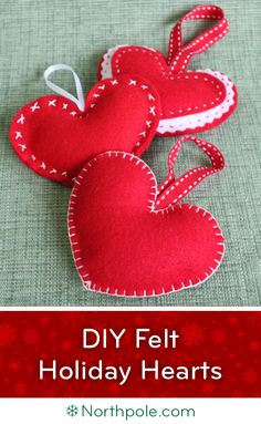 two red heart shaped ornaments sitting on top of a table