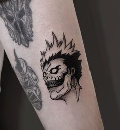 a man's arm with a tattoo on it that has a skull and demon head