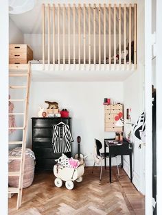 a room with a loft bed, desk and ladder in the ceiling above it is a black chest of drawers