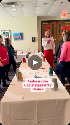 a group of women standing around a table with christmas decorations on it and the caption ambassador christmas party games