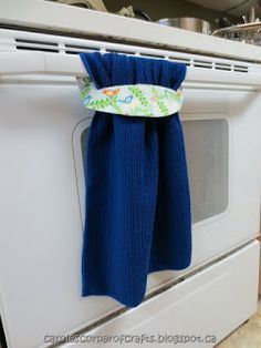 a blue towel hanging from the handle of an oven door on top of a white stove