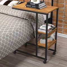 a bed with a wooden nightstand next to it on top of a hard wood floor