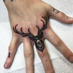 a person's hand with tattoos on it and two antlers painted on the palm