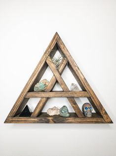 a wooden triangle shelf with rocks and air plant