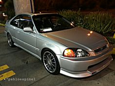 a silver car parked in a parking lot at night