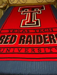 a bed with a red and black blanket on it