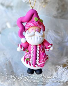 a pink and white christmas ornament with a santa clause