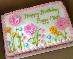 a birthday cake decorated with pink and yellow flowers