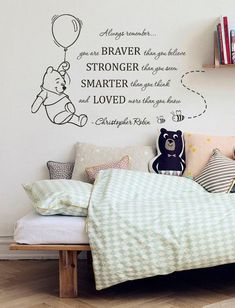 a child's bedroom with a winnie the pooh wall decal and bed