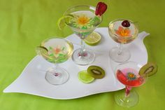 several wine glasses are sitting on a white tray with flowers and leaves painted on them