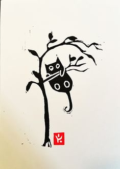 a black cat sitting on top of a tree next to a red box with an arrow