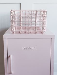 a pink metal cabinet with baskets on top