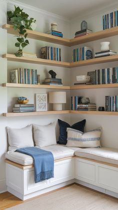 a white couch sitting in front of a book shelf filled with books