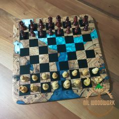 a chess board made out of wood and pieces of black and white checkerboard