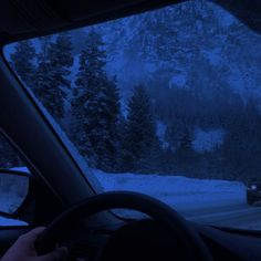 a car driving down a snowy road at night