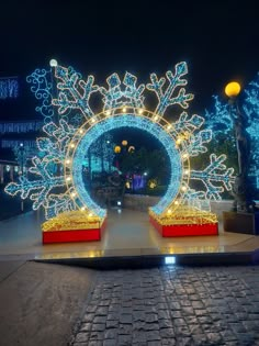 an outdoor display with snowflakes and lights in the shape of a circular mirror