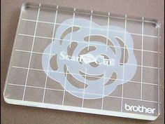 a clear plastic coaster with the word brother on it and a white rose in the center